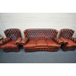 AN OXBLOOD THREE PIECE CHESTERFIELD SUITE, comprising a three seater sofa, length 202cm, and a