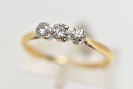 A YELLOW AND WHITE METAL THREE STONE DIAMOND RING, three illusion set round brilliant cut