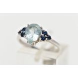 A 9CT WHITE GOLD GEM SET RING, set with a pear cut aquamarine, flanked each side with three circular