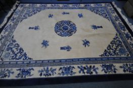 A CHINESE CREAM AND BLUE WOOLLEN CARPET, 370cm x 275cm (condition:-in need of cleaning)