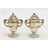 A PAIR OF SILVER PEPPERETTES, each in the form of a trophy cup fitted with double scrolling handles,