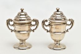 A PAIR OF SILVER PEPPERETTES, each in the form of a trophy cup fitted with double scrolling handles,