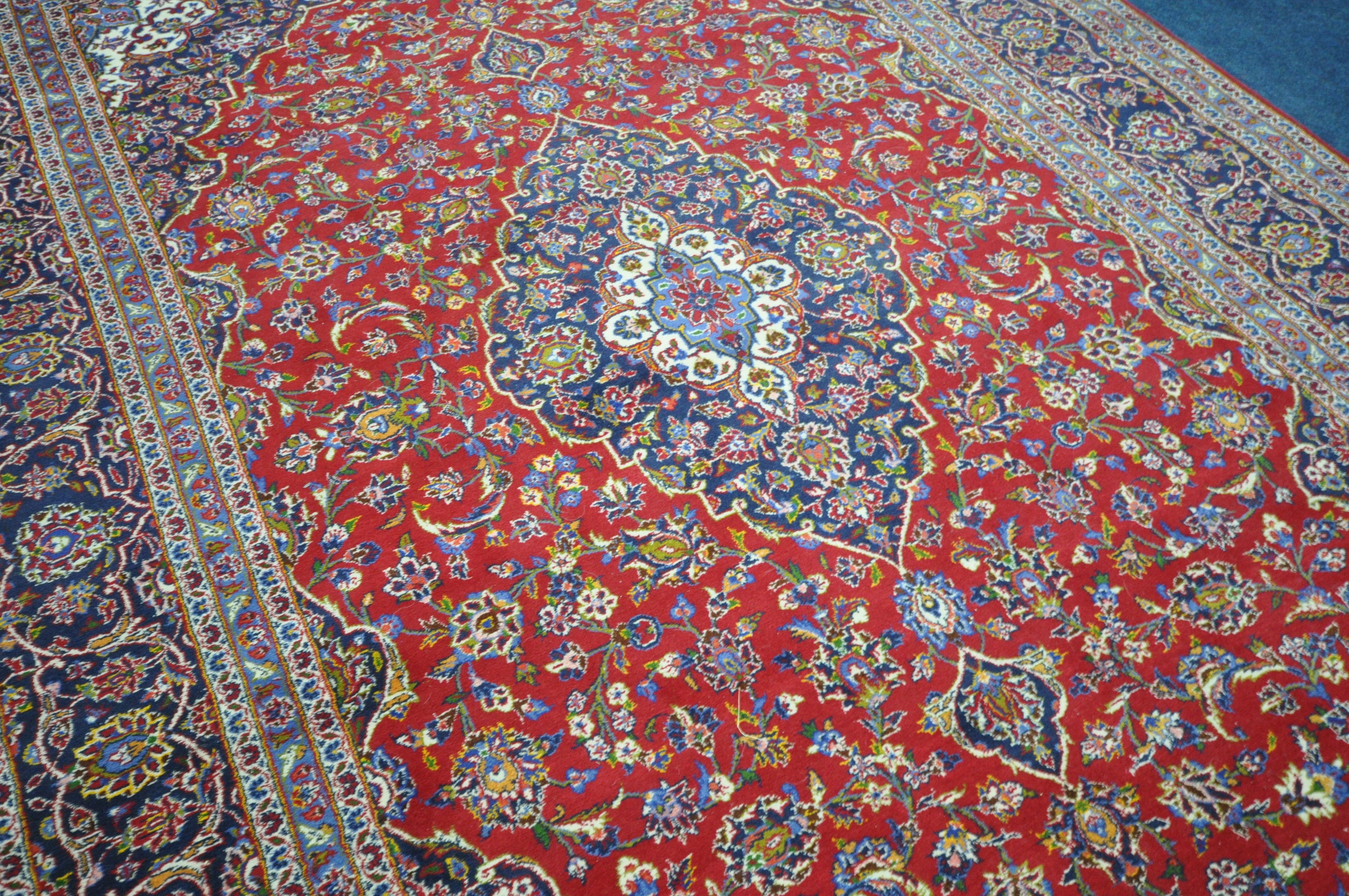 A 20TH CENTURY KASHAN RUG, with a central medallion, within a blue and red field, and a multi - Image 3 of 5