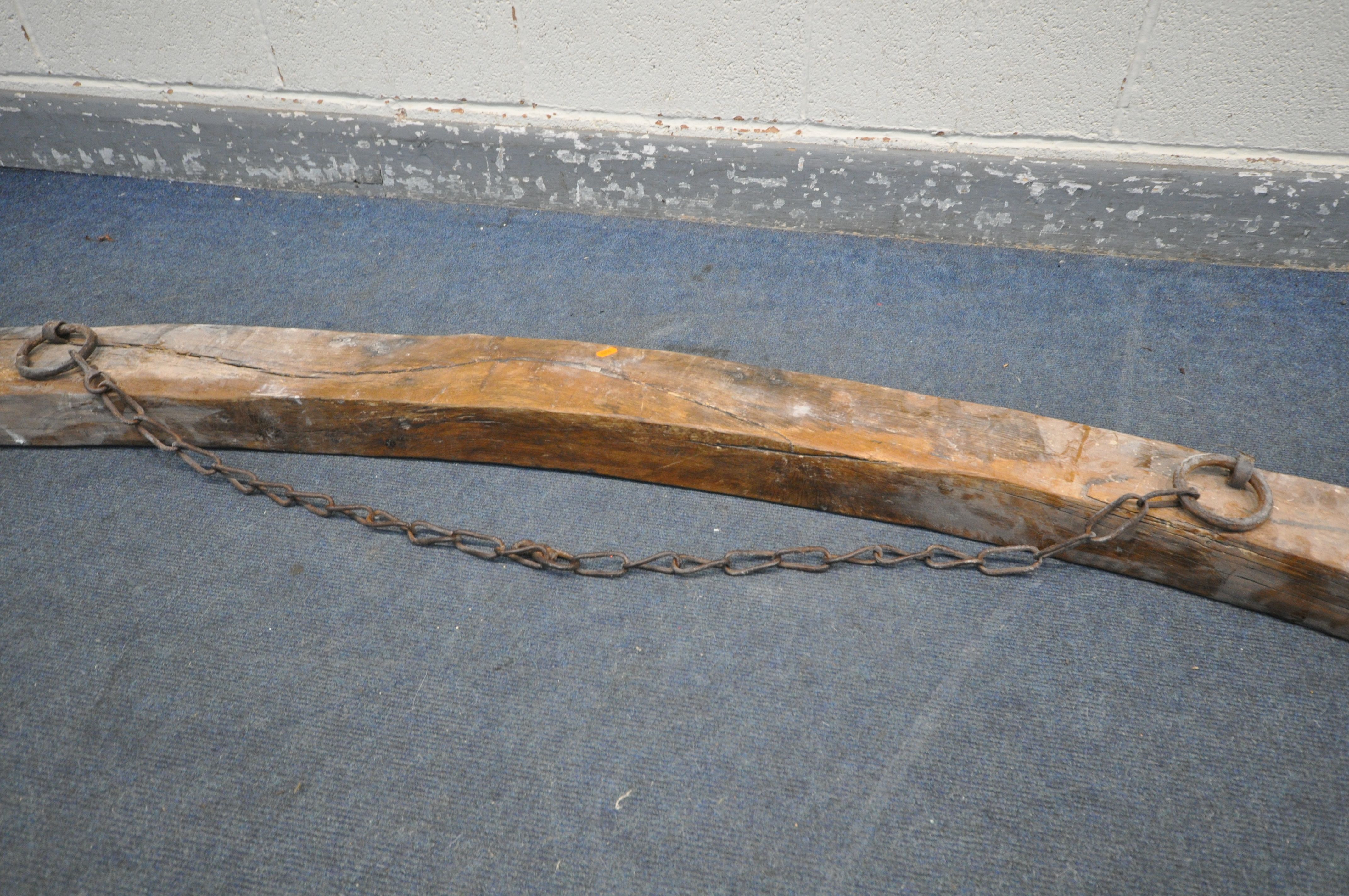 AN ANTIQUE RECLAIMED WOOD CURVED BEAM, with an iron chain, approx. length 244cm - Image 4 of 4