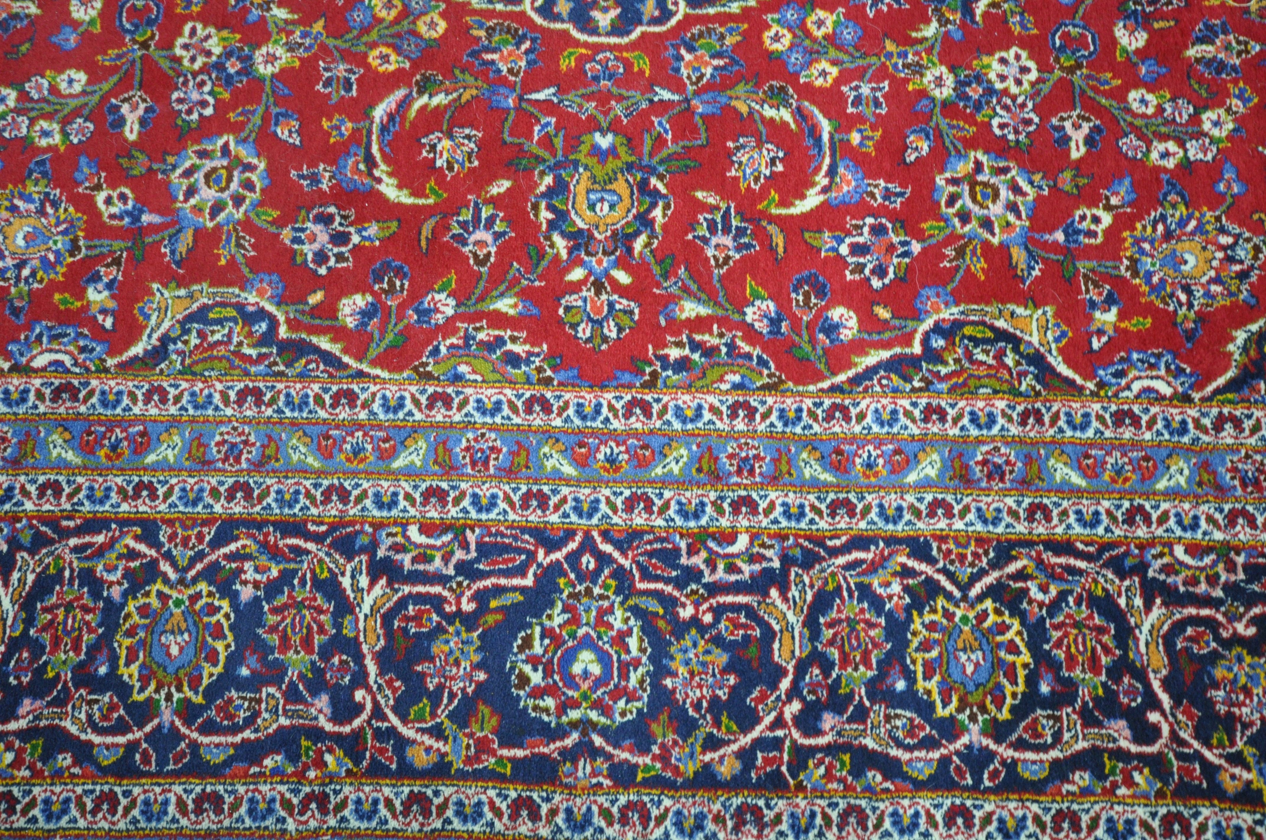 A 20TH CENTURY KASHAN RUG, with a central medallion, within a blue and red field, and a multi - Image 4 of 5