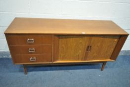 A MID CENTURY AUSTINSUITE TEAK SIDEBOARD, with double tambour doors, besides three graduated