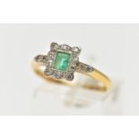 A YELLOW METAL EMERALD AND DIAMOND CLUSTER RING, set with a central rectangular cut emerald,