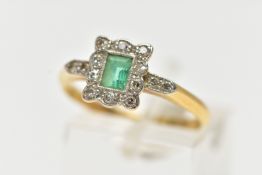 A YELLOW METAL EMERALD AND DIAMOND CLUSTER RING, set with a central rectangular cut emerald,