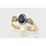 A 18CT GOLD SAPPHIRE AND DIAMOND RING, an oval cut deep blue sapphire bezel set, flanked with two