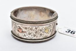 A WHITE METAL HINGED BANGLE, wide bangle engraved with a floral detail and yellow metal birds,