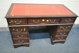 A MAHOGANY PEDESTAL DESK, with a red leather writing surface, and eight assorted drawers, with two