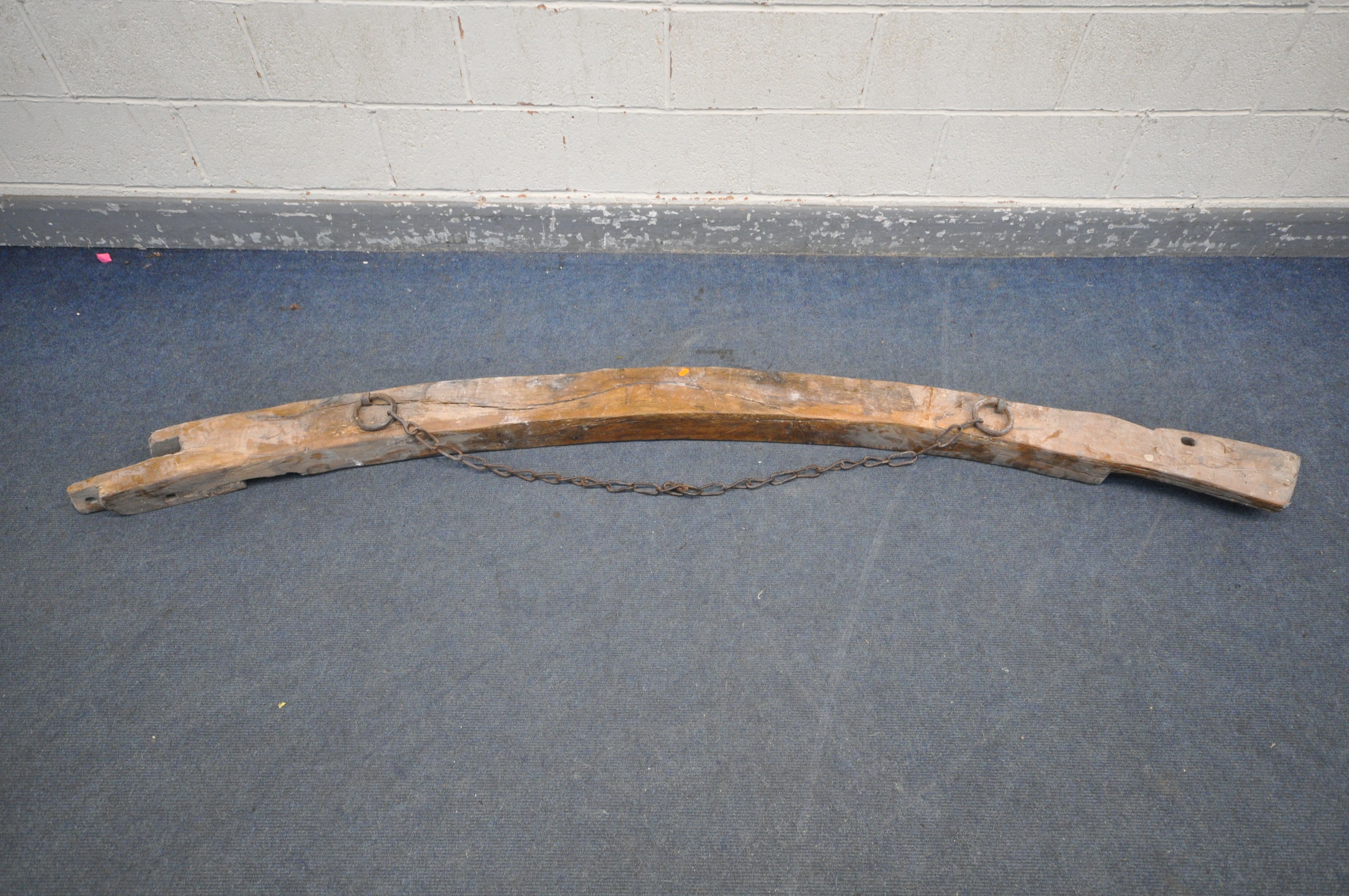 AN ANTIQUE RECLAIMED WOOD CURVED BEAM, with an iron chain, approx. length 244cm