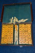 A LEATHER CASED MAHJONG SET, with bone and plastic pieces in fixed and pull out trays, case