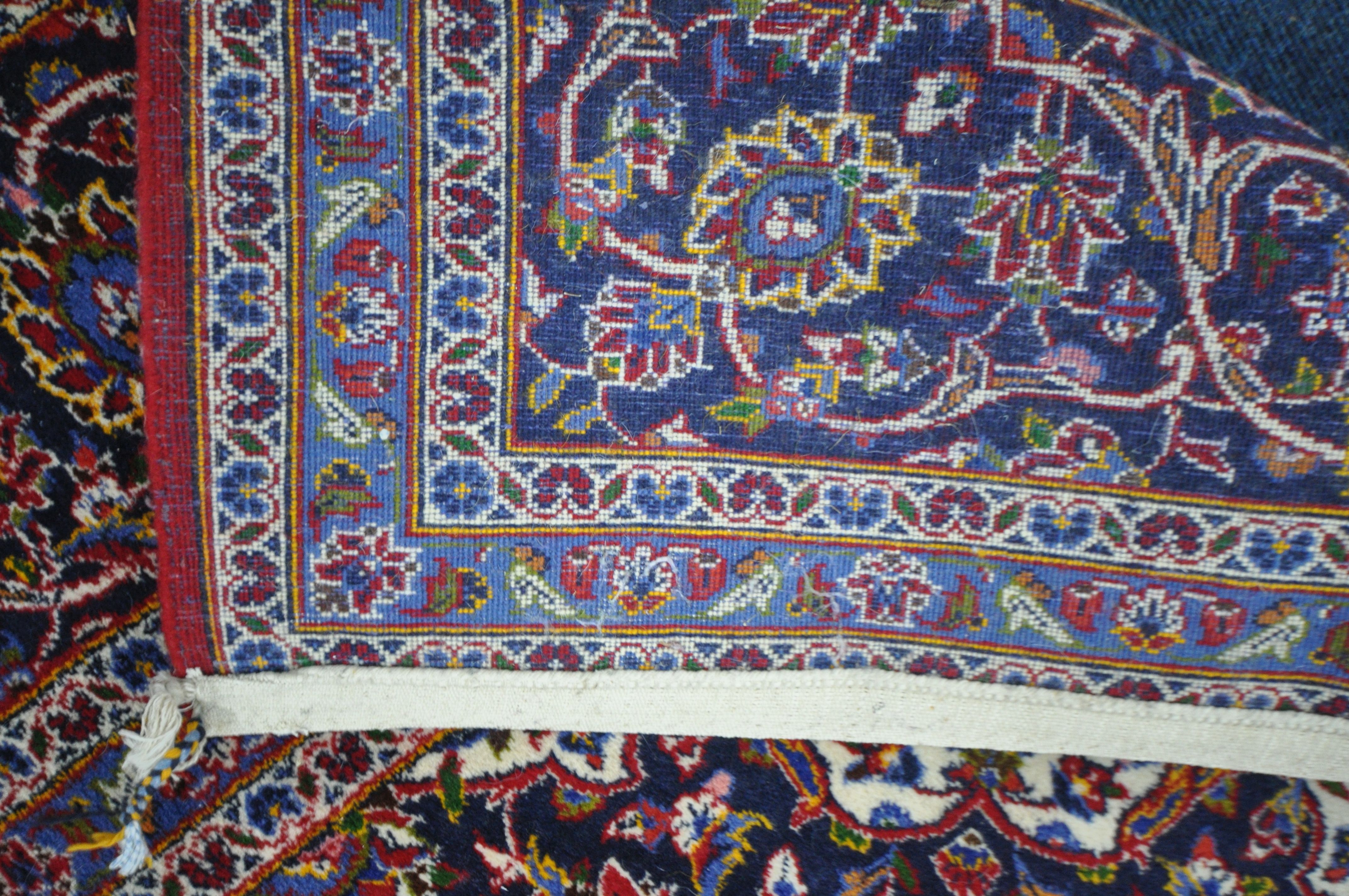 A 20TH CENTURY KASHAN RUG, with a central medallion, within a blue and red field, and a multi - Image 5 of 5