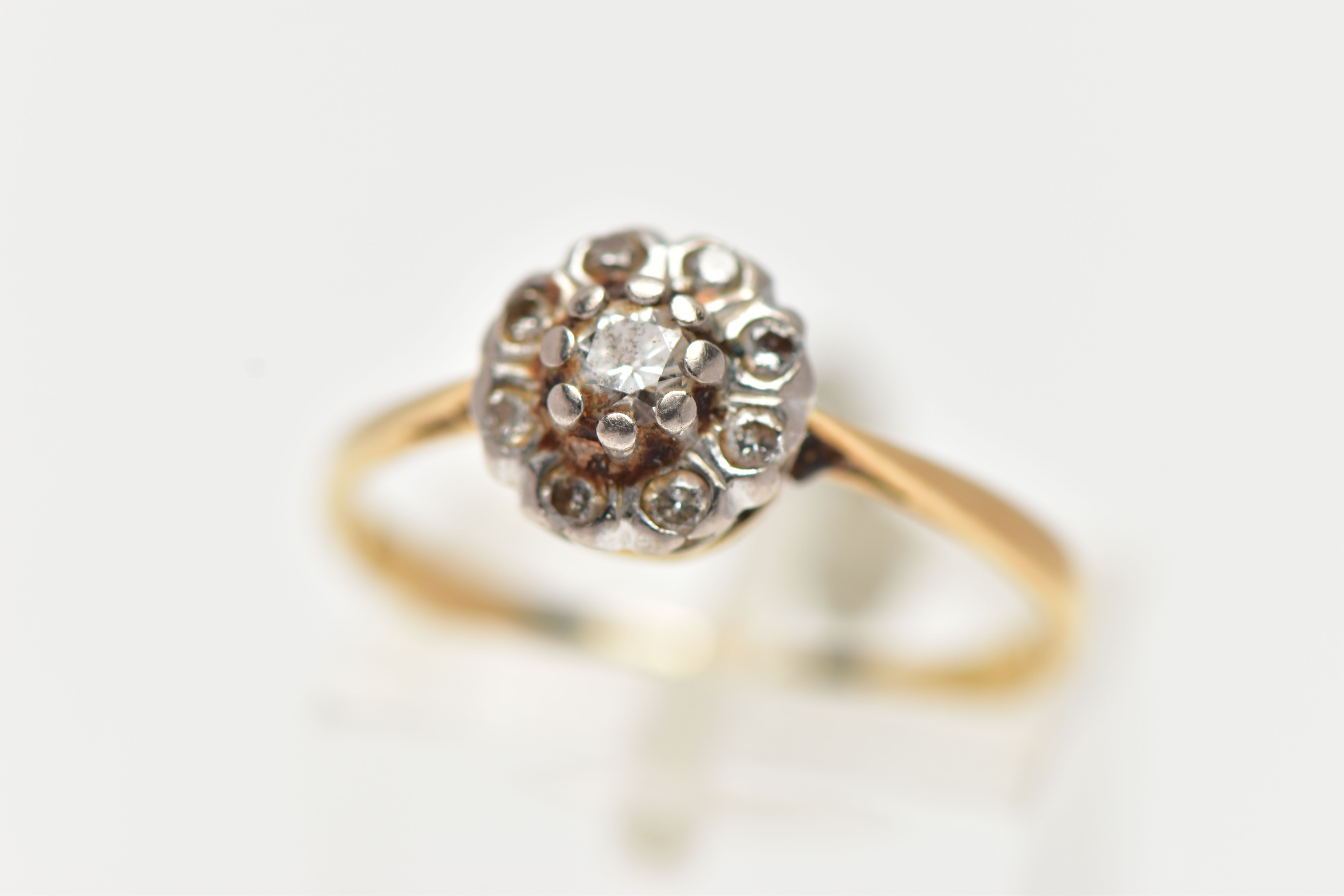 A YELLOW METAL DIAMOND FLOWER RING, set with nine round brilliant cut diamonds, estimated total