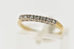 A YELLOW METAL DIAMOND HALF ETERNITY RING, set with a row of seven round brilliant cut diamonds,