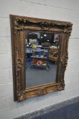 A LARGE RECTANGULAR GILT FRAMED BEVELLED EDGE WALL MIRROR, frame with foliate detailing, 129cm x