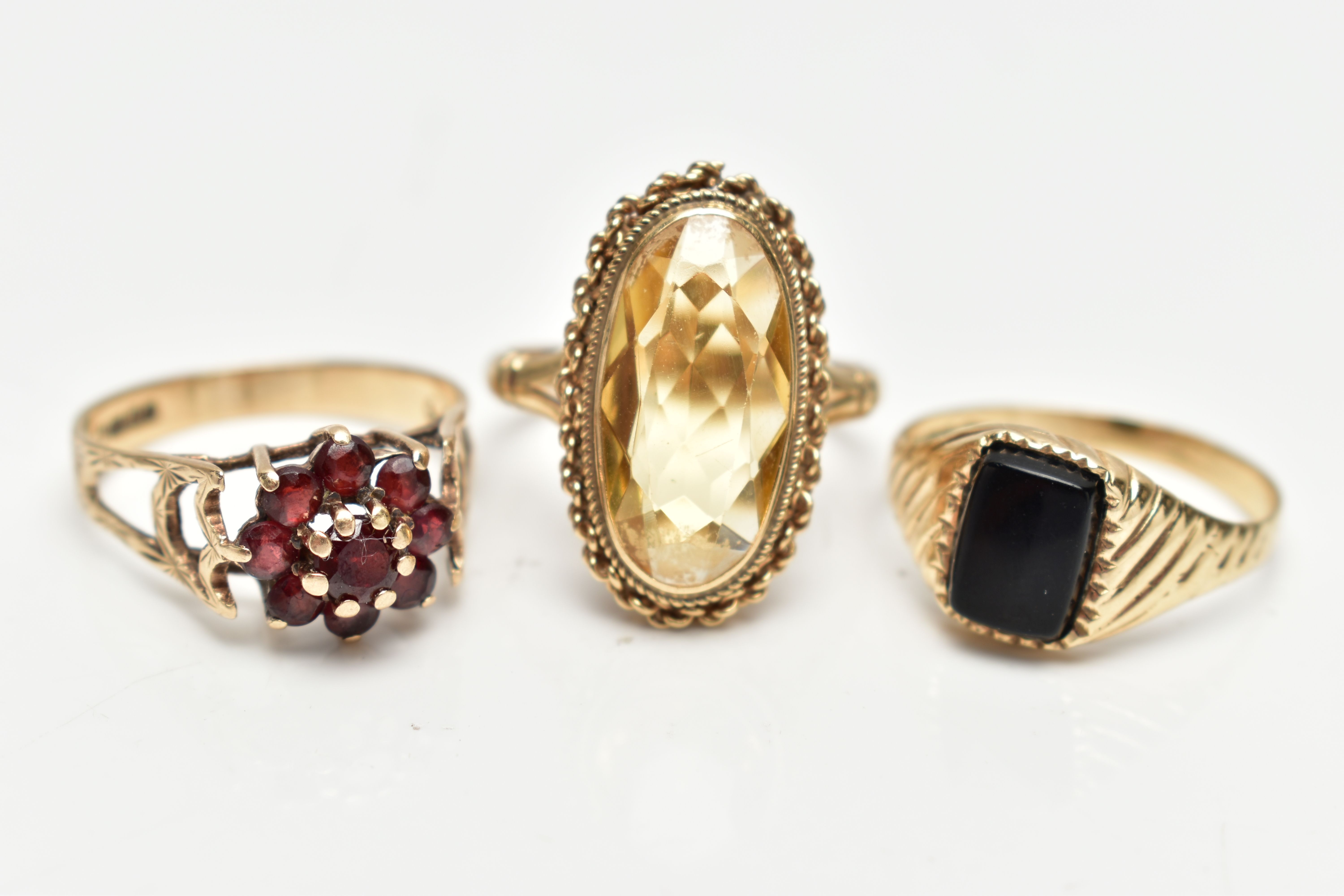 THREE 9CT GOLD RINGS, the first a yellow gold signet ring, set with a rectangular cut onyx stone,