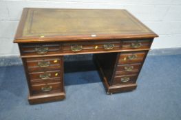 AN EDWARDIAN WALNUT PEDESTAL DESK, with a brown leather writing surface, and nine drawers, on