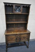 AN OAK DRESSER, top with a single lead glazed door, base with two cupboard doors, width 107cm x