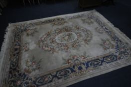 A LARGE RECTANGULAR BEIGE GROUND CHINESE WOOLEN RUG, with multistrap border, and foliate decoration,