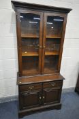 A 20TH CENTURY OAK BOOKCASE, top with two glazed doors, base with two drawers over two doors,