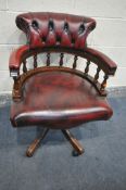 A BURGUNDY LEATHER UPHOLSTERED SWIVEL OFFICE CHAIR, with shaped button back, width 65cm x depth 67cm