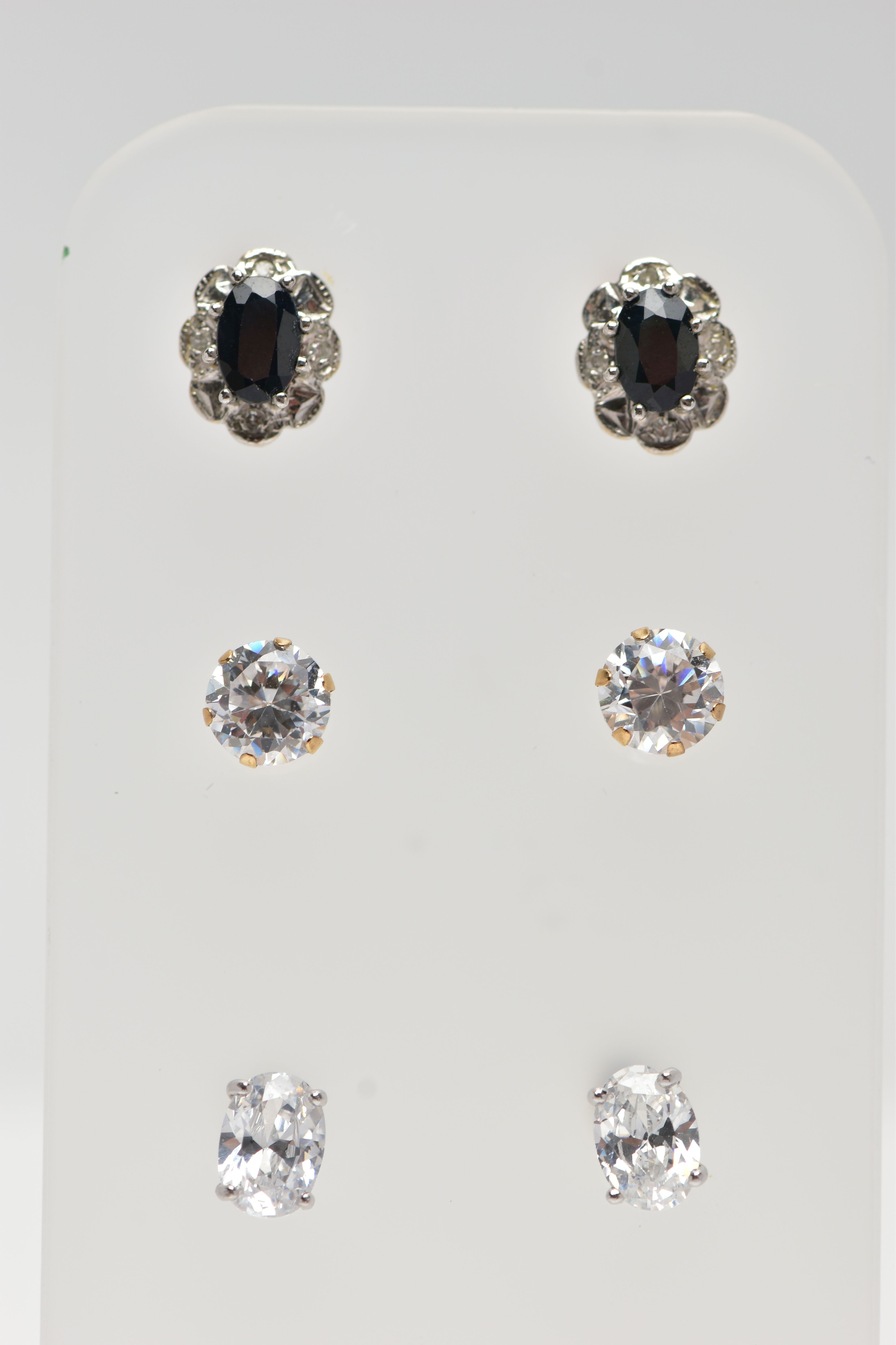 THREE PAIRS OF GEM SET EARRINGS, the first a pair of cluster stud earrings, set with an oval cut