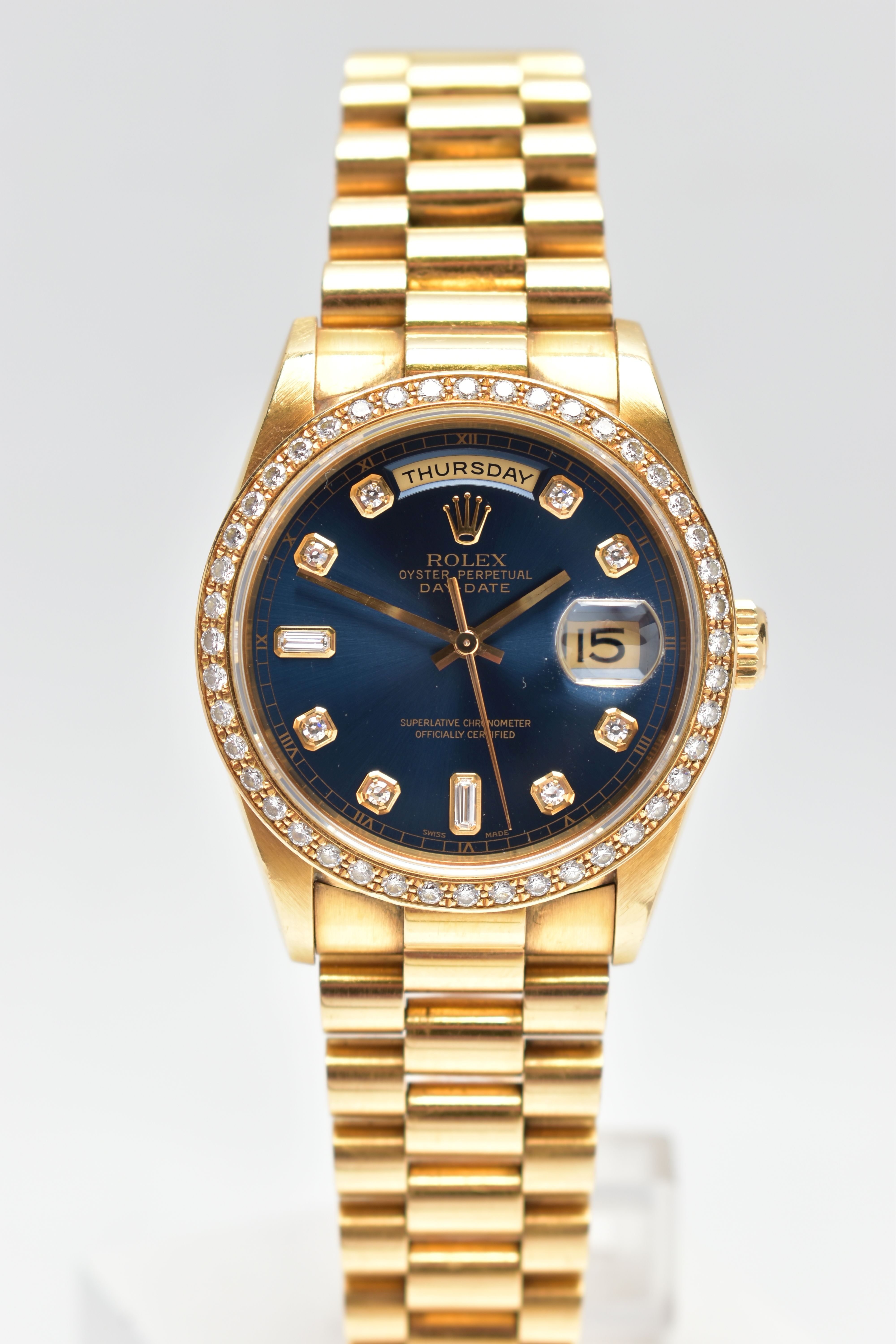 AN 18CT YELLOW GOLD AND DIAMOND DAY-DATE ROLEX WRISTWATCH, the dark blue dial with diamond dot