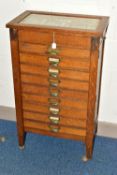 OPTOMETRIST INTEREST: AN EARLY 20TH CENTURY RECTANGULAR OAK CABINET WITH GLAZED CASE ABOVE NINE