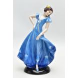 A 1930'S CONTINENTAL PORCELAIN FIGURE OF A LADY IN A LONG BLUE DRESS, modelled standing on an oval