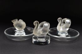 TWO LALIQUE RING / PIN TRAYS AND A LALIQUE PAPERWEIGHT, the two clear glass ring trays with a