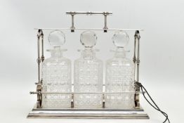 A LATE VICTORIAN ELECTRO PLATED TANTALUS IN THE STYLE OF CHRISTOPHER DRESSER, the horizontal bar