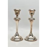 A PAIR OF ELIZABETH II FILLED SILVER CANDLESTICKS, concentric reeded band decoration to the top rim,