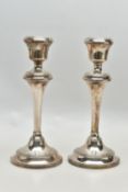 A PAIR OF ELIZABETH II FILLED SILVER CANDLESTICKS, concentric reeded band decoration to the top rim,