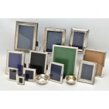 TWELVE SILVER PHOTOGRAPH FRAMES AND TWO SMALL SILVER PLATED BOWLS, all of the photograph frames