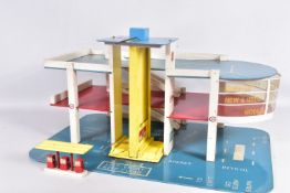 A VINTAGE WOODEN THREE TIERED MODEL SERVICE STATION WITH LIFT, in blue, white, red and yellow,