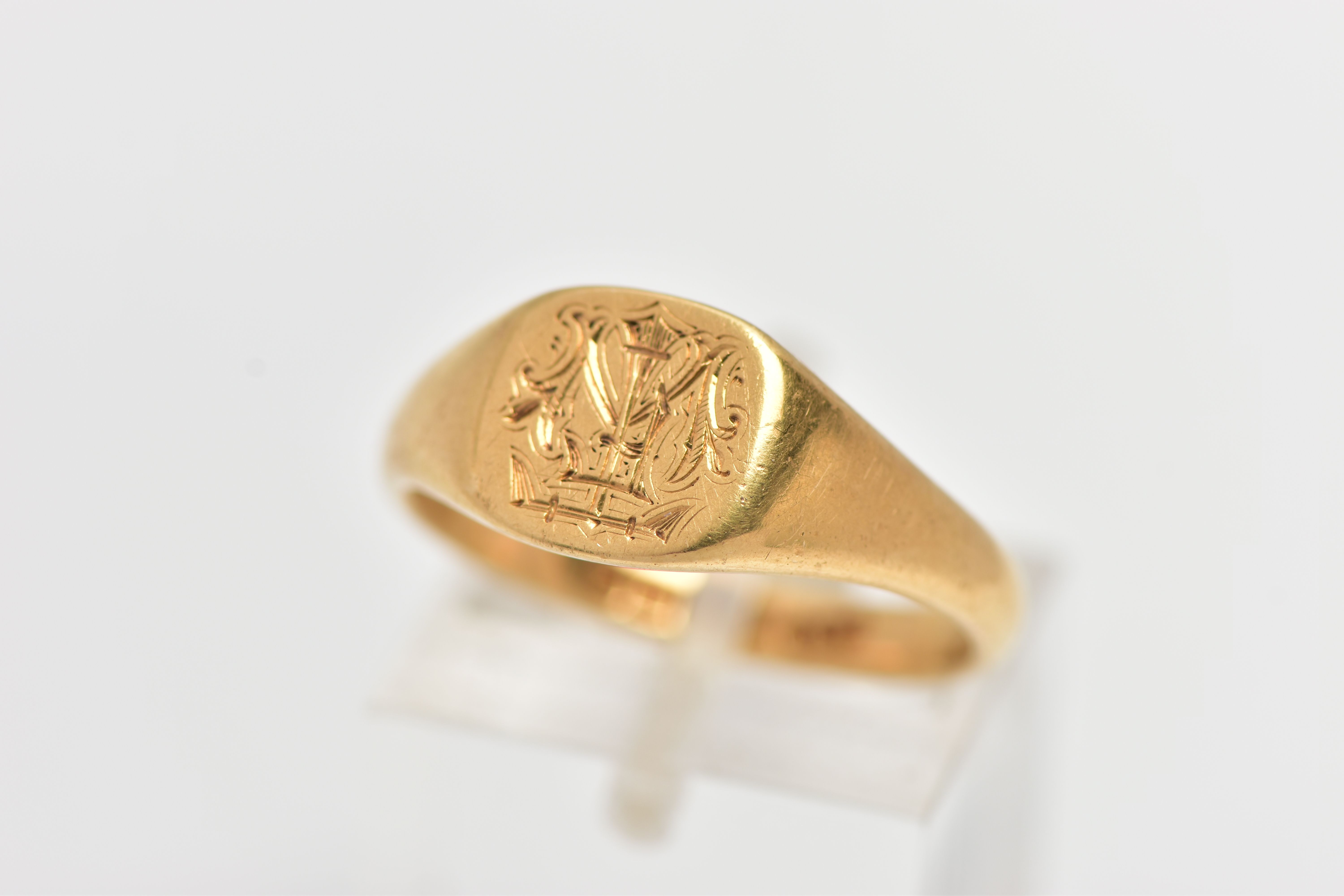 AN 18CT YELLOW GOLD SINGET RING, of a square form with engraved initial monogram to the centre,