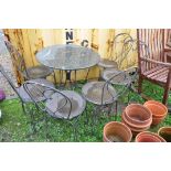 A HEAVY METAL FRAMED PATIO SET with a marble topped round table 75cm in diameter and six similar