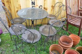 A HEAVY METAL FRAMED PATIO SET with a marble topped round table 75cm in diameter and six similar