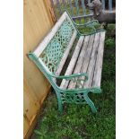 A WOODEN SLATTED GARDEN BENCH with cast iron ends and back panel 127cm wide (Condition weathered
