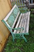 A WOODEN SLATTED GARDEN BENCH with cast iron ends and back panel 127cm wide (Condition weathered