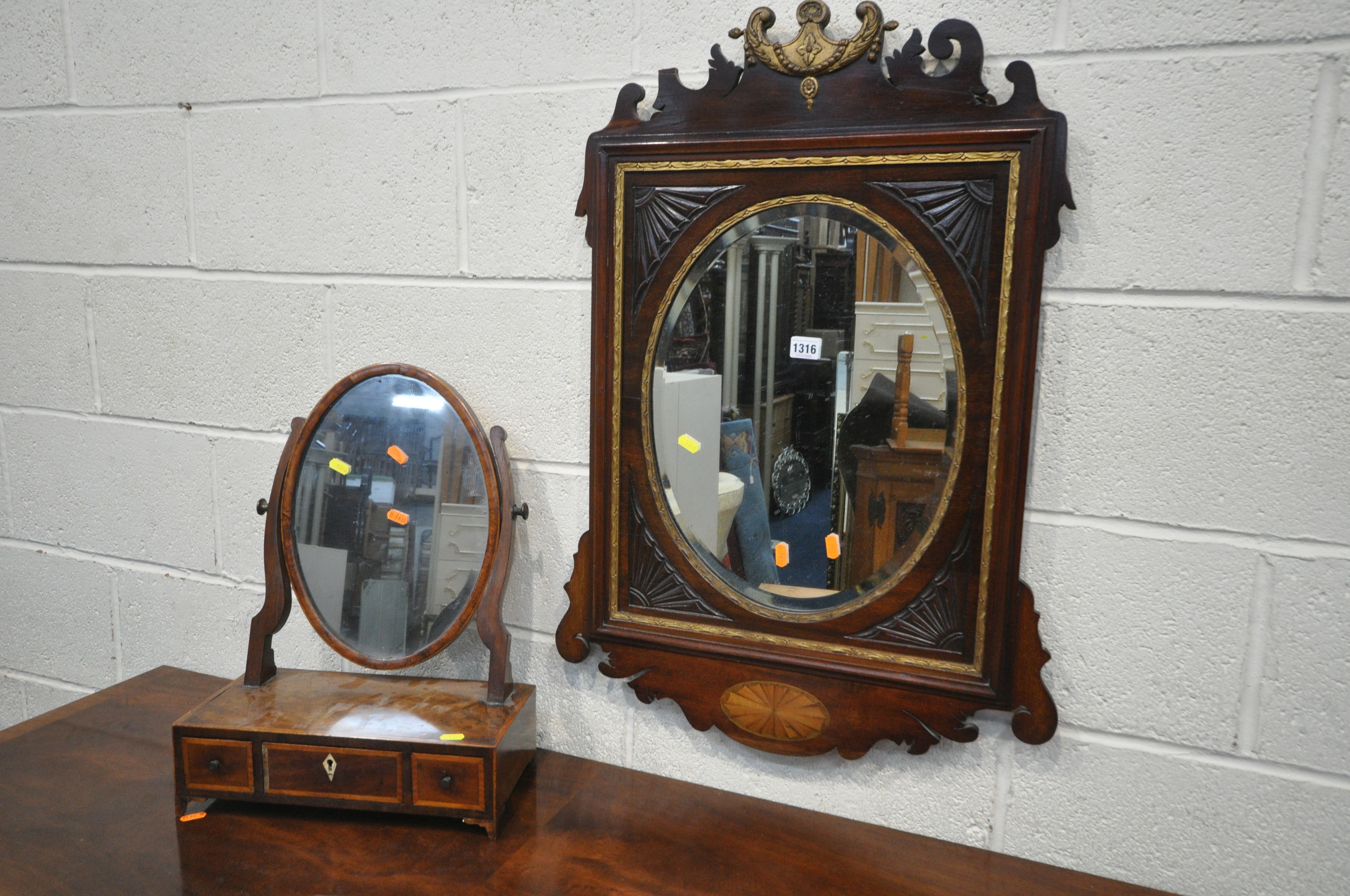 AN EARLY 19TH CENTURY MAHOGANY AND GILT FRETWORK FRAMED WALL MIRROR, with an oval bevelled plate,