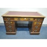 AN EDWARDIAN OAK PEDESTAL DESK, with burgundy leatherette writing surface, and nine various drawers,