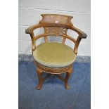 AN EARLY 20TH CENTURY OAK CAPTAINS CHAIR, with shaped raised back, and pierced details, swept open