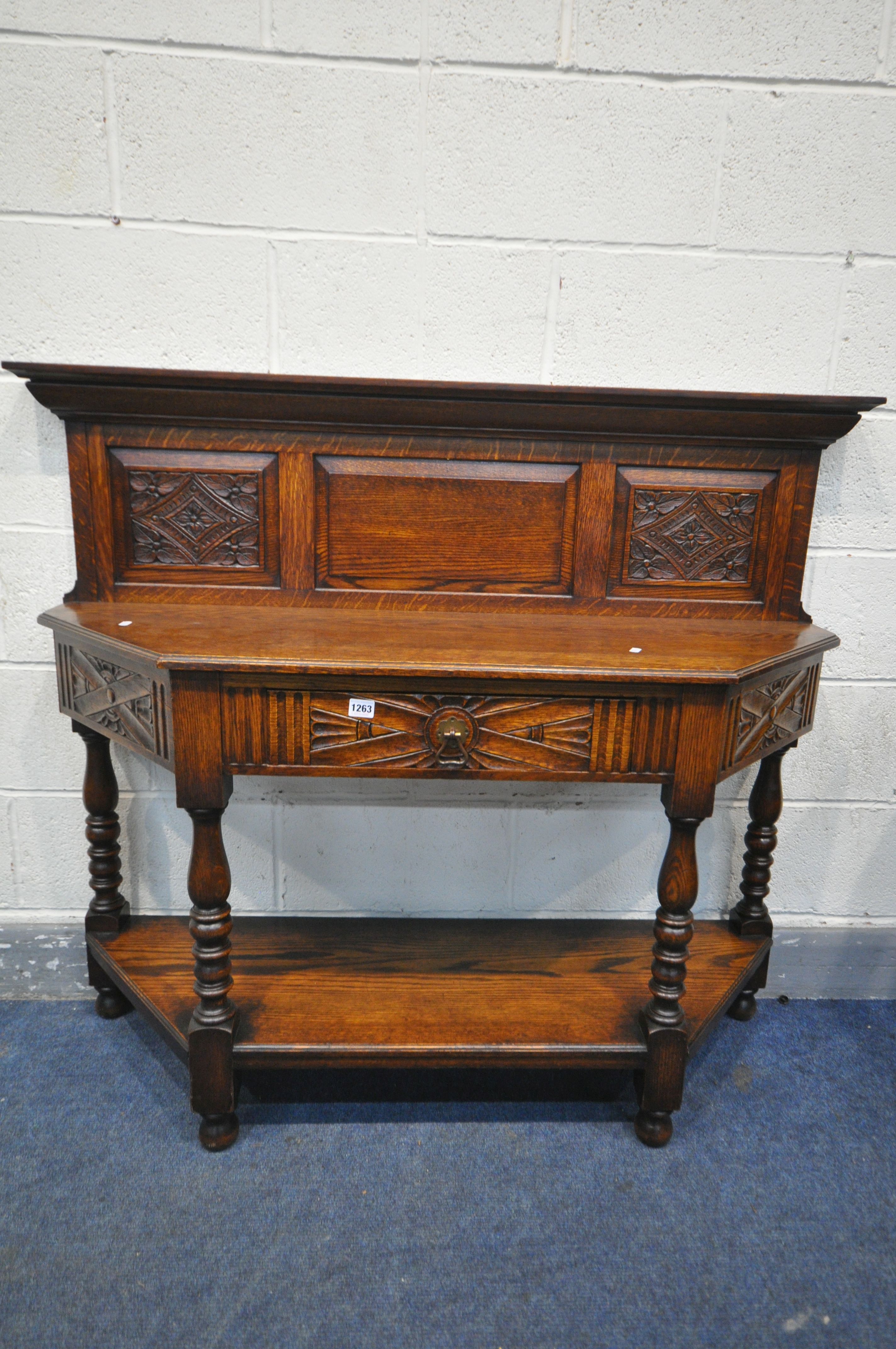 A 20TH CENTURY CANTED OAK SIDE TABLE, with a raised panelled back, a single frieze drawer, on turned