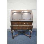 AN EARLY 20TH CENTURY OAK BUREAU, with two drawers, on bulbous legs, united by a cross stretcher,