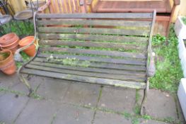 A WOODEN SLATTED GARDEN BENCH with lion mask cast iron ends 131cm wide (Condition very weathered and