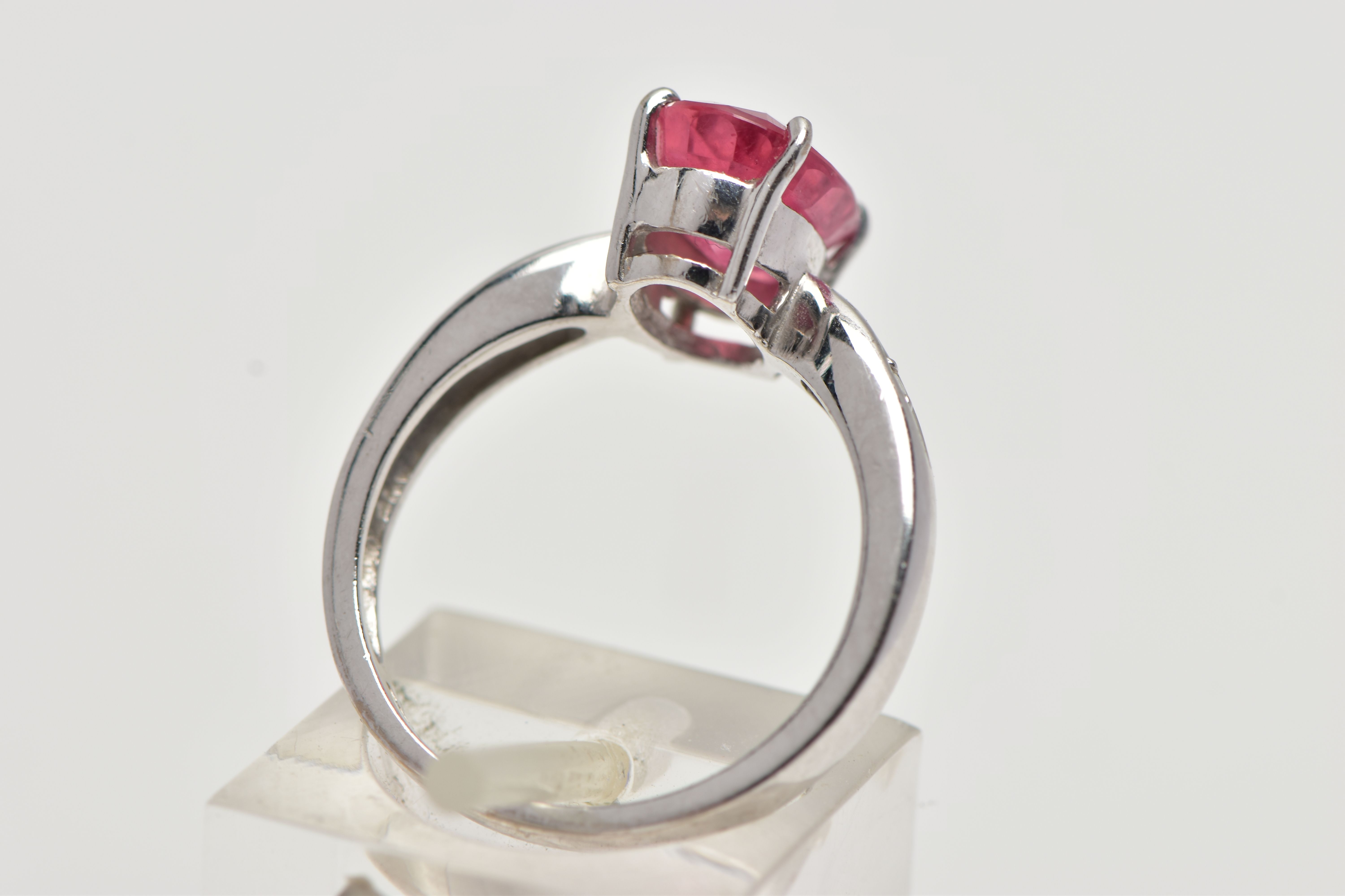 AN 18CT WHITE GOLD RING, centrally set with an oval cut orange/red colour corundum, flanked with two - Image 3 of 4