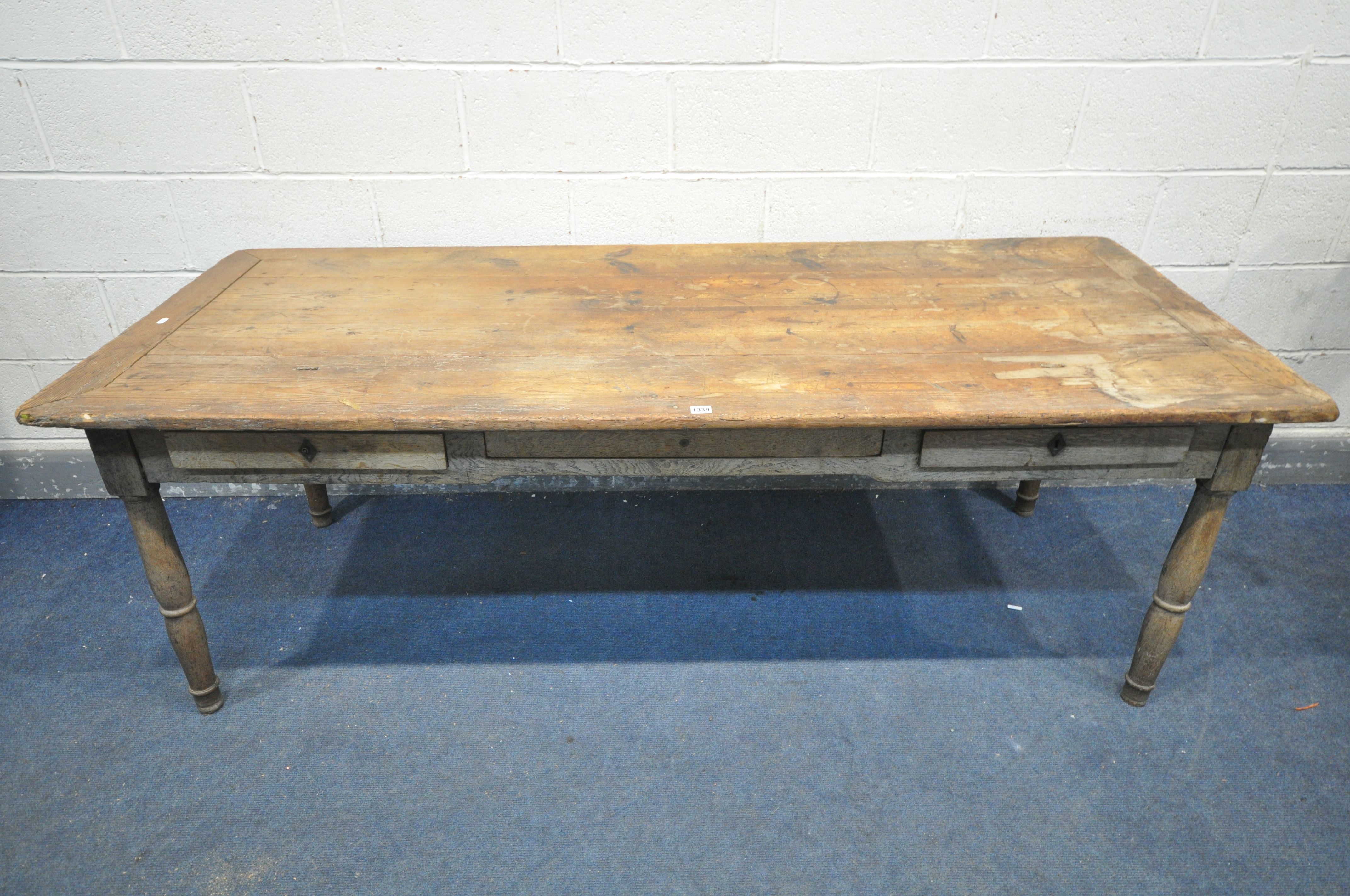 A 19TH CENTURY FARMHOUSE TABLE, the pine top with penny slots, three frieze drawers, on an oak base,